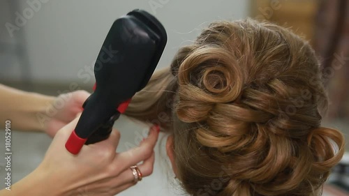 Professional Hair Dresser Used Hair Curler Iron for brunette Hair at beauty salon