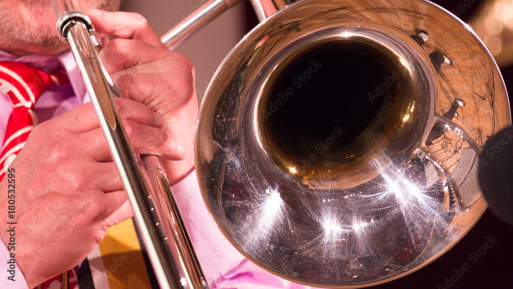 Obraz premium In the hands of a musician a trombone while playing jazz. close-up