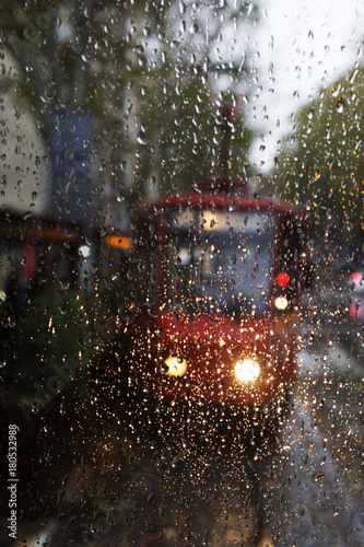 Glass with rain drops, the glass visible red tram