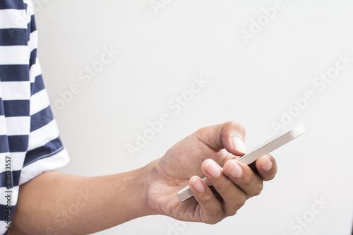 Close up of men  hands holding touching mobile phone with blank copy space for your text message on gray background with light Sunset Vintage tone.Selective focus