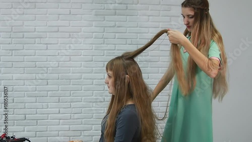 A professional stylist makes a hairstyle for the model. Fashion world.