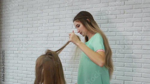 A professional stylist makes a hairstyle for the model. Fashion world.