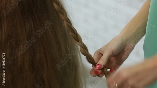 A professional stylist makes a hairstyle for the model. Fashion world.