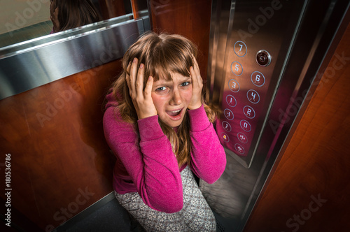 Shocked woman with claustrophobia in the moving elevator