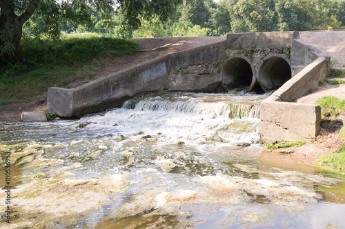 stone pond drainage with small waterfall. background, nature.
