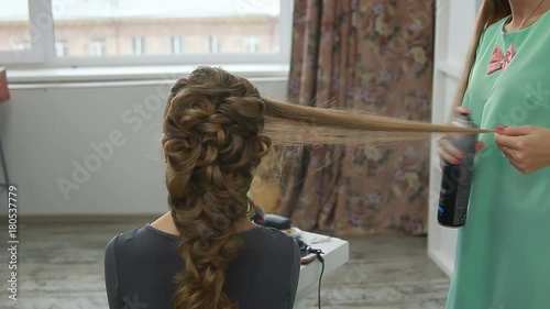 A professional stylist makes a hairstyle for the model. Fashion world.