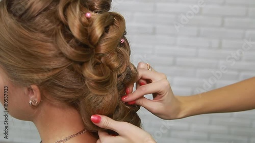 A professional stylist makes a hairstyle for the model. Fashion world.