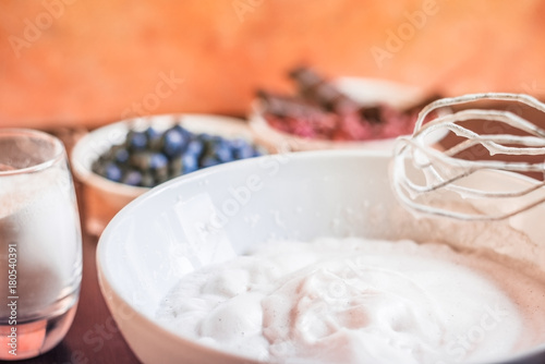 Whipped egg whites for meringue. Mixing white egg cream in bowl with motor mixer, baking cake. Anna Pavlova meringue. Whipped egg whites and sugar powder. Baking dessert concept