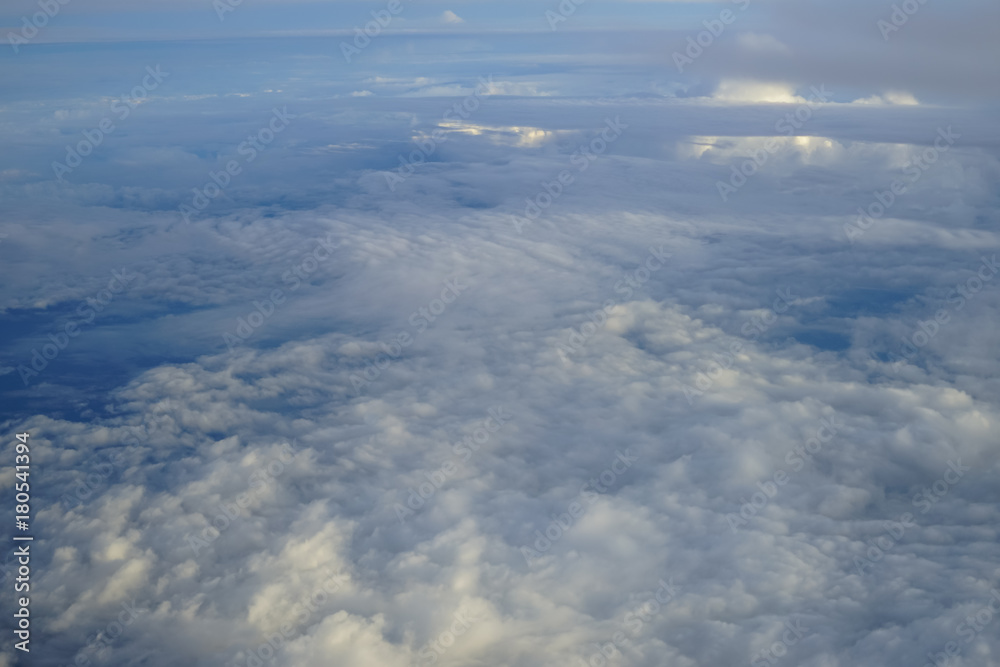 Fototapeta premium View of beautiful abstract soft white cloud with shades of blue sky background from above flying plane window