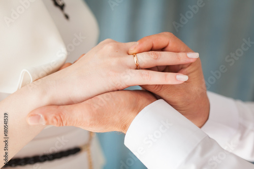 Wedding ceremony. He puts the engagement ring on his finger close-up. Bride and groom
