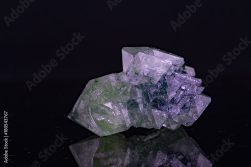Green natural crystal mineral on a black background