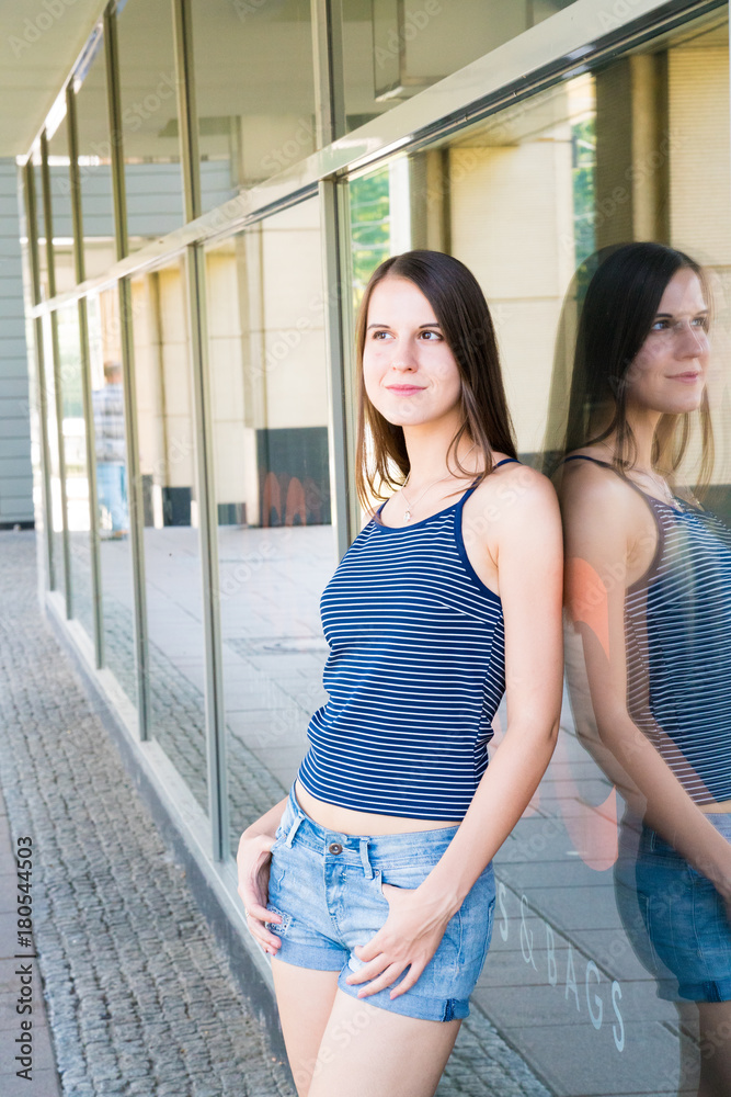 Pretty girl in a blue Topic and shorts posing in the city Pretty girl in a blue Topic and shorts posing in the city