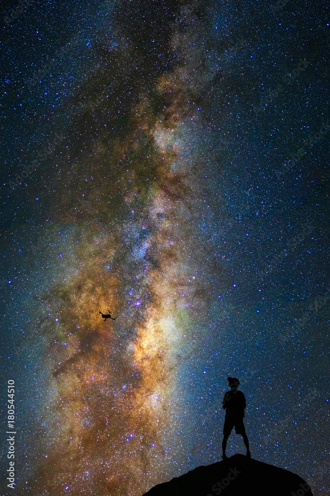 Fototapeta premium Silhouette of photographer with drone over the milky way on the dark sky background, photographer and transportation with astrophotography concept