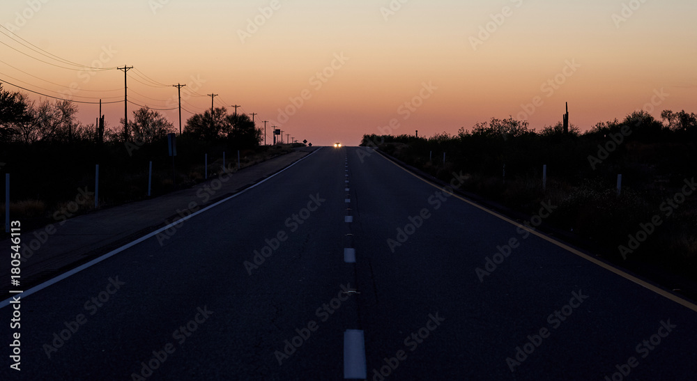 Car coming on a highway after sunset.