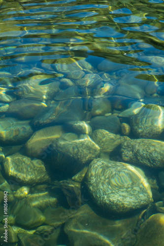 Obraz na płótnie Close up of green and blue background of pebbles and stones under water w salonie