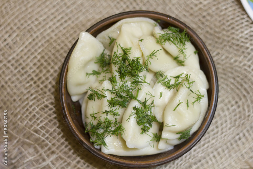 Closeup view of traditional russian food - pelmeni, ravioli or meat dumplings. Served with marinated mushrooms, sauerkraut, cucumbers, green onion and garlic. Copy space Closeup view of traditional russian food - pelmeni, ravioli or meat dumplings. Served with marinated mushrooms, sauerkraut, cucumbers, green onion and garlic. Copy space