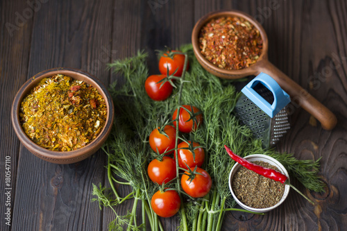 tomatoes, dill, chili and spices on a wooden table
