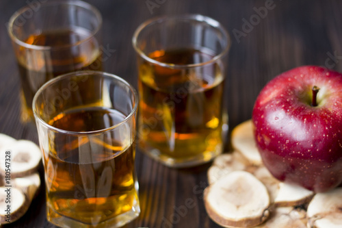 red Apple with Apple juice on a wooden table close up