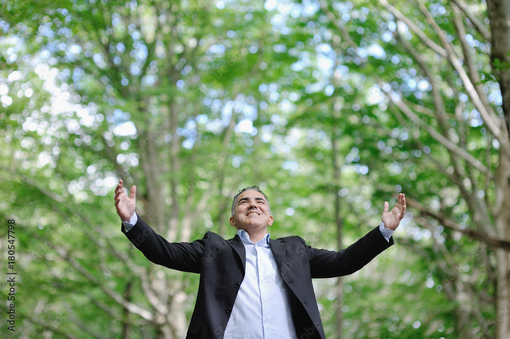 Smiling caucasian man in a forest - success relax freedom concept Smiling caucasian man in a forest - success relax freedom concept