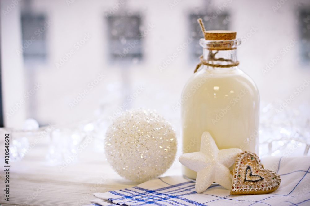 New Year's still-life with a bottle of milk, biscuits, Christmas-tree blue ball, tablecloth in a box Christmas-tree toy in the form of a white star and a white New Year's ball. New Year's still-life with a bottle of milk, biscuits, Christmas-tree blue ball, tablecloth in a box Christmas-tree toy in the form of a white star and a white New Year's ball.