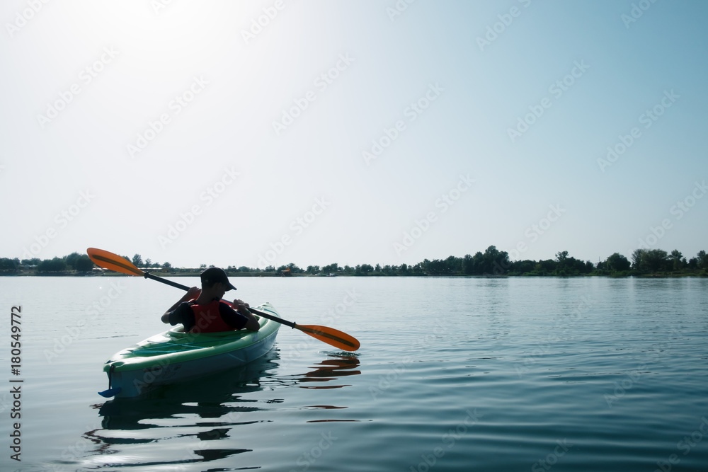 Boy in life jacket on green kayak