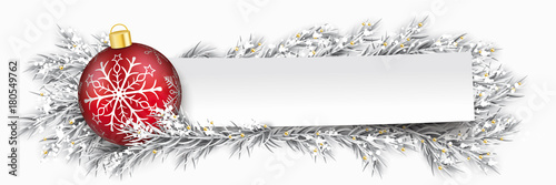 Papierzettel mit einer Weihnachtskugel und eingeschneiten Tannenzweigen
