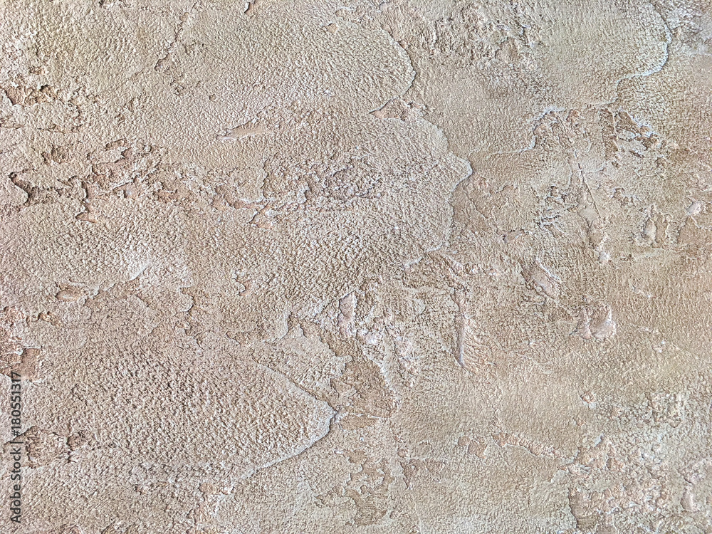 Old beige wall covered with uneven plaster. Texture of vintage shabby sand stone surface, closeup.