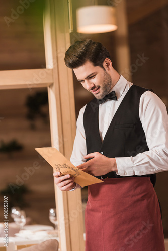 Waiter looking at menu