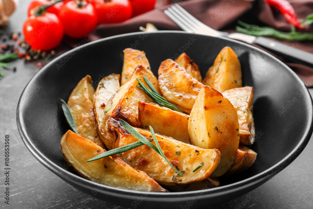 Plate with delicious baked rosemary potatoes on table Plate with delicious baked rosemary potatoes on table