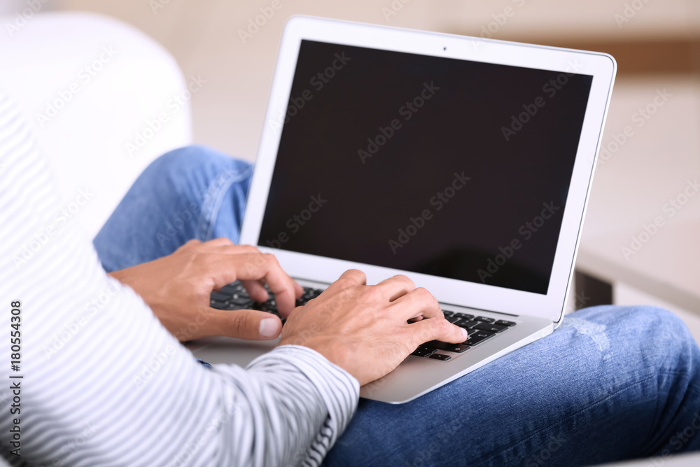 Fototapeta premium Young man using laptop at home
