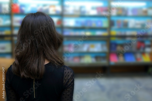 Student in front of a large bookshelf.
