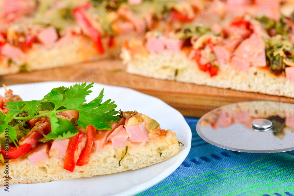 Metal round knife and slices of home made pizza