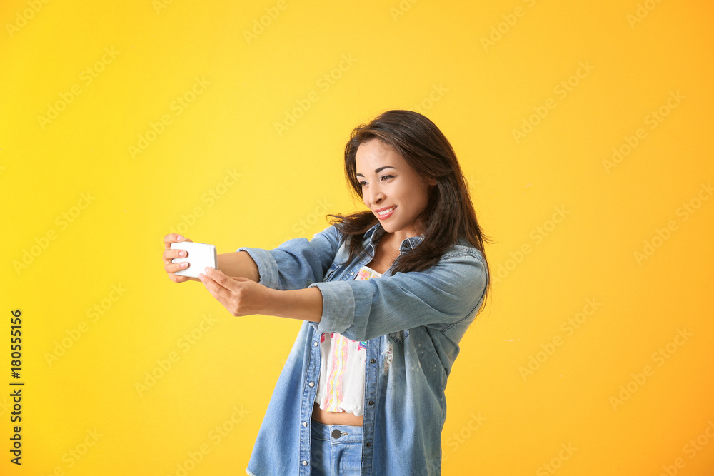 Beautiful woman taking selfie on color background Beautiful woman taking selfie on color background