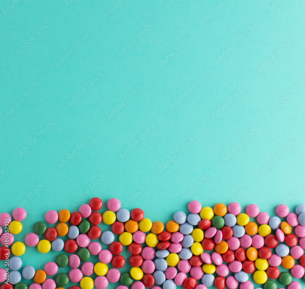 Obraz premium colorful chocolate candy group on blue mint background free space top view