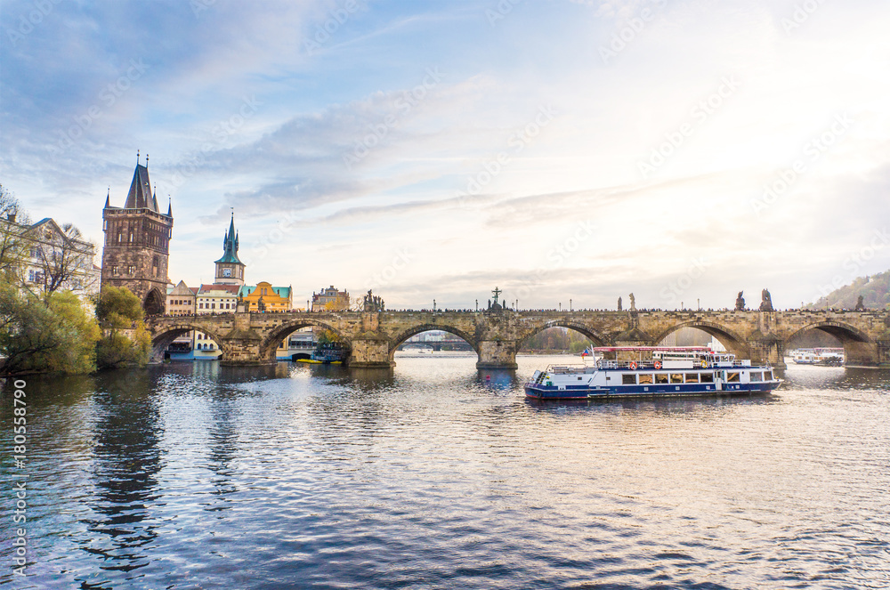 Charles Bridge and a boat cruise in Vltava river in Prague, Czech Republic.