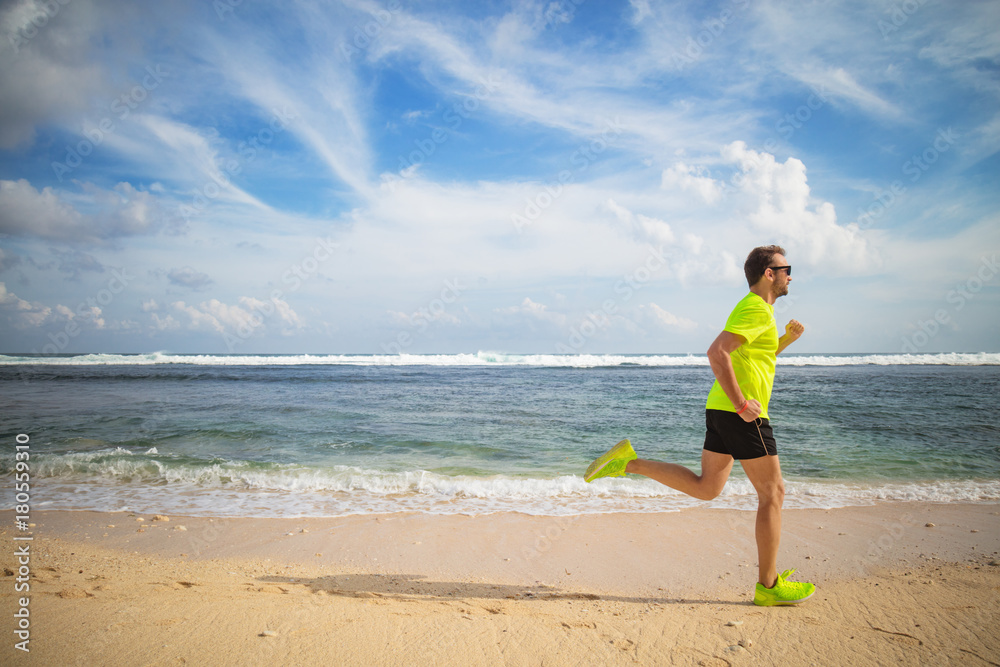 Jogging on a tropical sandy beach near sea / ocean.