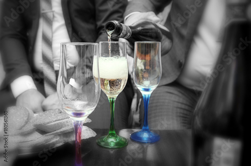 pour champagne from the bottle in the colored glasses, at the wedding, black and white background © Андрей Глущенко