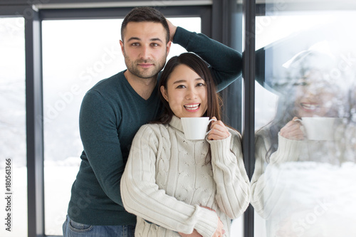 multiethnic couple enjoying morning coffee by the window © .shock