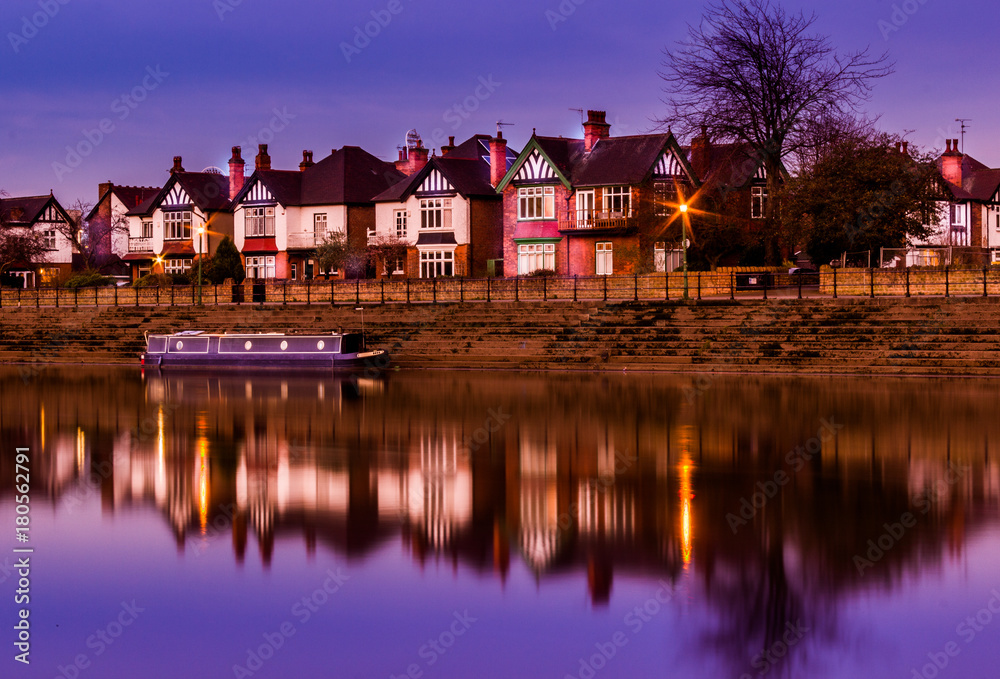 reflections at dusk on a river of a barge