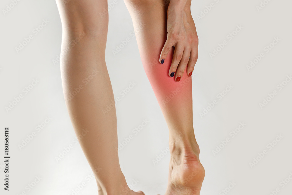 The girl has a pain in his leg. Holding his hands behind his leg. Closeup The girl has a pain in his leg. Holding his hands behind his leg. Closeup
