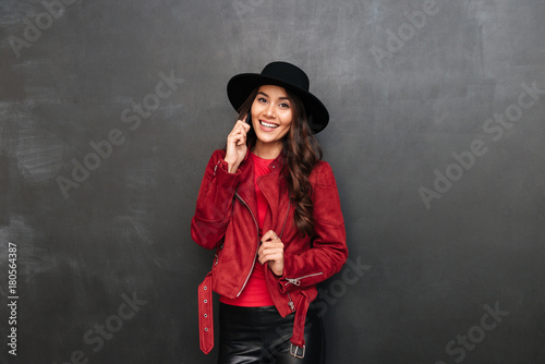 Cheerful young woman wearing hat talking by mobile phone © Drobot Dean