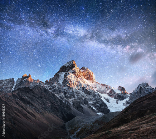 Fantastic starry sky. Autumn landscape and snow-capped peaks. Main Caucasian Ridge. Mountain View from Mount Ushba Meyer, Georgia. Europe