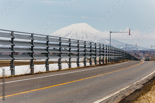 Road with road block with Mount Yotei in the background in winter in Hokkaido, Japan.