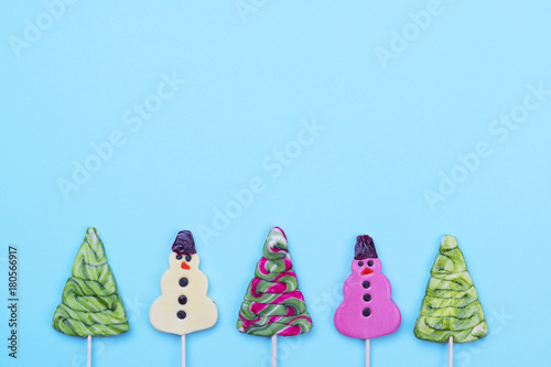 Colorful creative layout forbwinter holidays. Candy lollipops of snowman and Christmas tree.