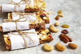 Healthy granola bars with nuts, seeds and dried fruits on the gray texture table, with copy space.