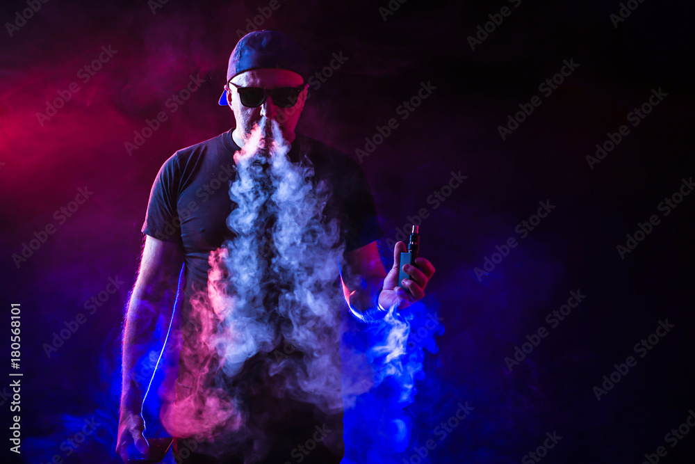 vaping man holding a mod. vape pen. vape smoke