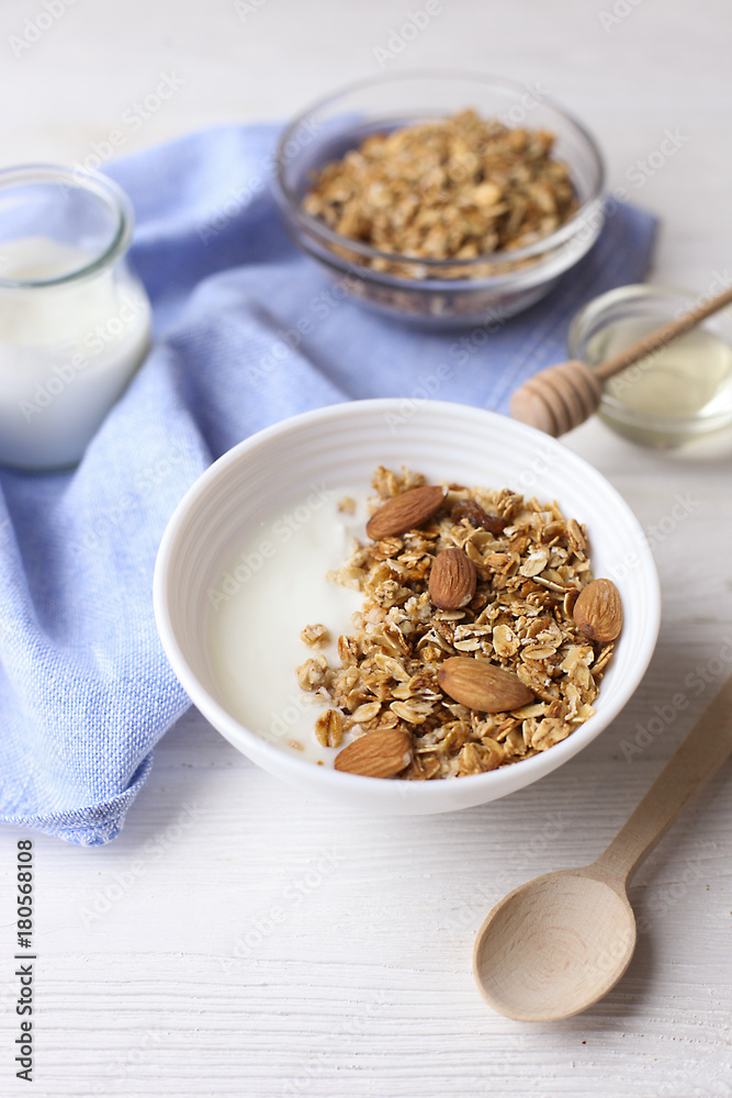 Homemade healthy granola or muesli with yogurt on white wooden background Homemade healthy granola or muesli with yogurt on white wooden background