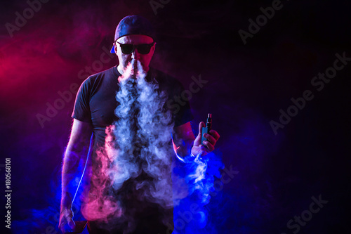 vaping man holding a mod. vape pen. vape smoke