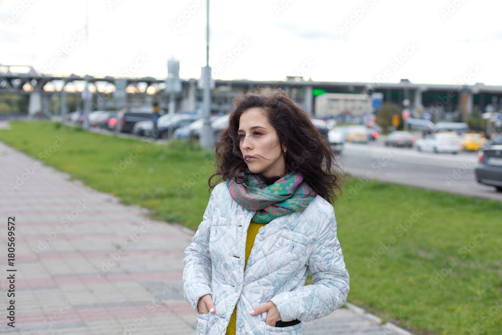 Fototapeta premium Portrait of a beautiful girl in an urban landscape in autumn