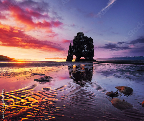 Is a spectacular rock in the sea on the Northern coast of Iceland. Legends say it is a petrified troll. On this photo Hvitserkur reflects in the sea water after the midnight sunset